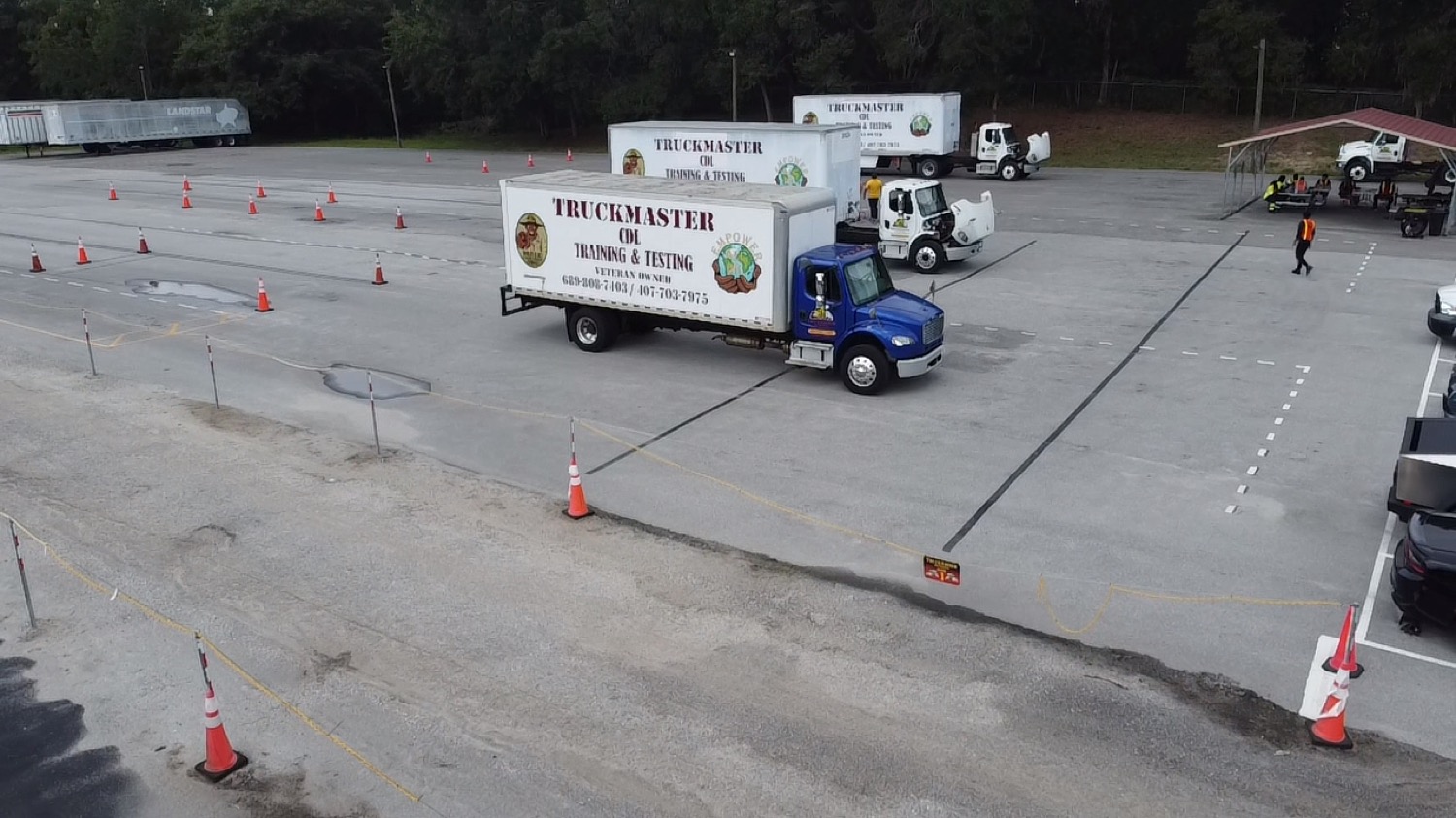 Aerial view of the TruckMaster CDL training yard with branded trucks and cone course in Apopka, FL